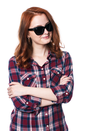 Young girl smiling with arms crossed in plaid shirt. Beautiful fashion woman in sunglasses isolated in studio on a white background.の写真素材