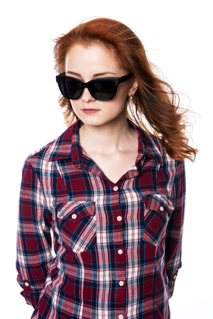 Beautiful woman with sunglasses in plaid shirt. Young fashion woman isolated in studio on a white background.の写真素材