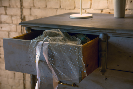 An open chest drawer with a transparent cloth on a brick wall background.の写真素材