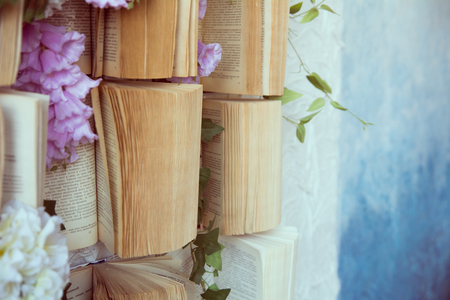 Concept background opened books on the wall and flowers of artificial purple and white.の写真素材