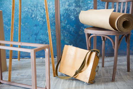 Roll of gray paper on a chair on a blue background in the artist's studio.の写真素材