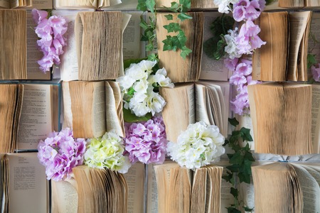 Background opened books on the wall and flowers artificial purple and white.の写真素材