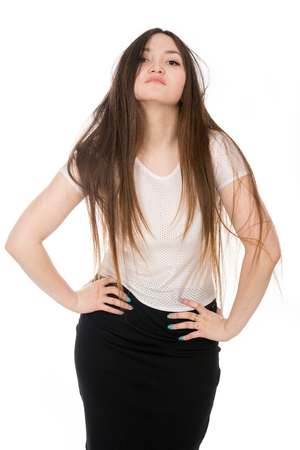 Portrait of a young asian woman with long hair isolated over white background. Girl in a light blouse with hands on the beltの写真素材