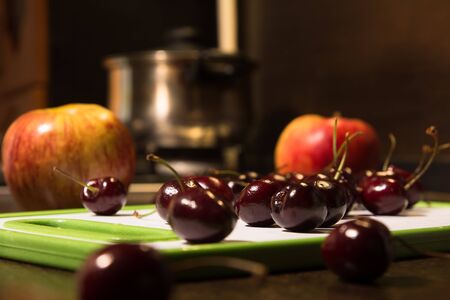 Background apples and cherries on the blackboard. Fruit on the kitchen table.の写真素材