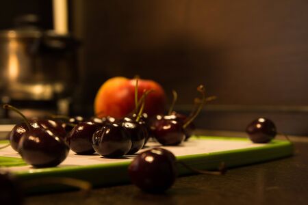 Background apples and cherries on the blackboard. Fruit on the kitchen table.の写真素材