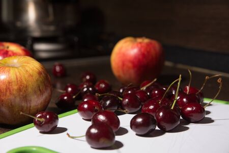 Background apples and cherries on the blackboard. Fruit on the kitchen table.の写真素材