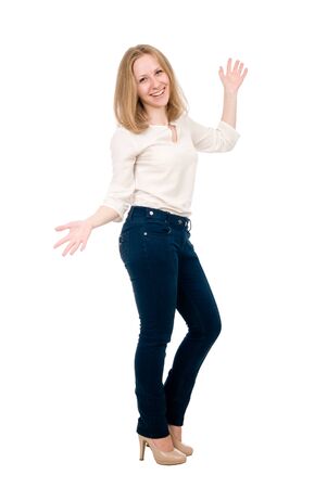 Portrait of a cheerful young woman in jeans with hands side isolated over white background.の写真素材