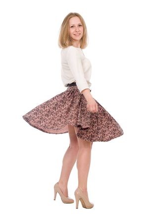 Portrait of a young woman with a skirt circling in full growth isolated over a white backgroundの写真素材