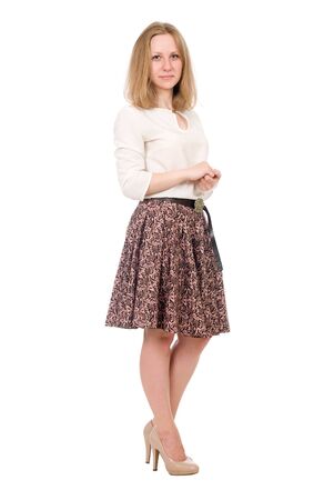 Fashion portrait of a young blonde in a skirt posing in full growth isolated over a white backgroundの写真素材
