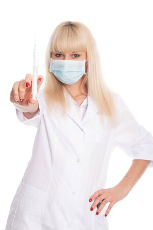 Masked nurse with syringe in hand. Doctor with vaccine isolated over a white backgroundの写真素材
