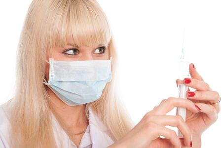 Close up of a young female nurse in a mask with a syringe. Doctor isolated on a white backgroundの写真素材