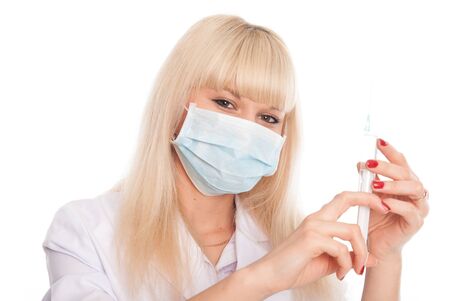 Close up of a young female nurse in a mask with a syringe. Doctor isolated on a white backgroundの写真素材