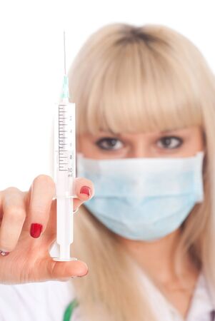 Close up of a young blonde nurse in a mask with a syringe. Doctor isolated on a white backgroundの写真素材