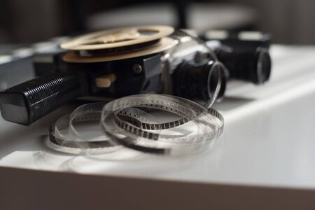 Film reel roll with movie camera and movie clapper on a light table. Accessories for filmingの写真素材