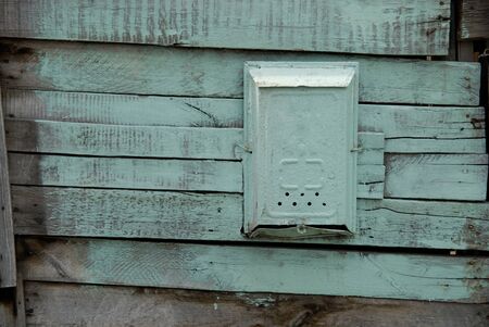 Old painted mail box on a wooden green wall.の写真素材