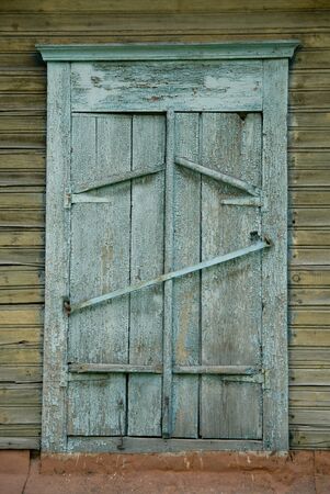 Background old wooden painted window closed by shutters. Village slumsの写真素材