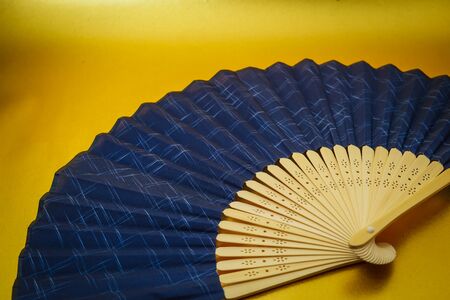 Fan placed on the gold backgroundの写真素材