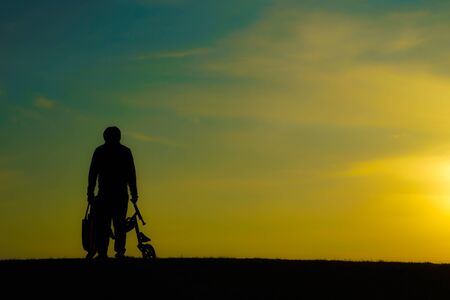 Silhouette of a man standing in the twilight of the hillの写真素材