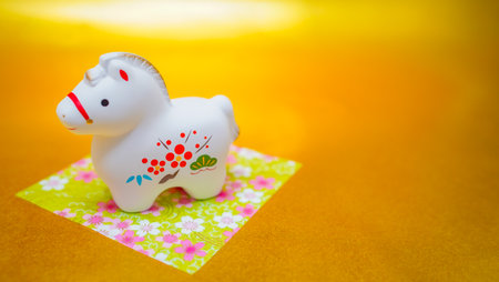 Year of the Horse figurine on a golden background. Shooting Location: Kanagawa Ward, Yokohama Cityの写真素材