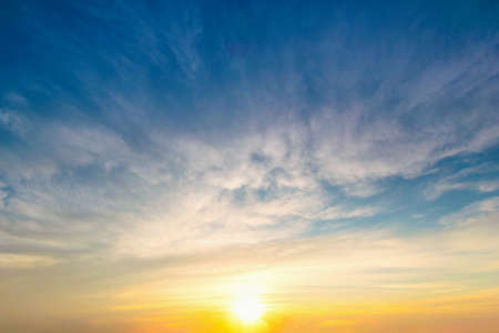Sky blue and orange light of the sun through the clouds in the sky