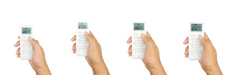 Hands holding remote control isolated on white background.の写真素材