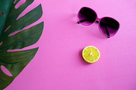 Summer still life with tropical Monstera leaf, lemon, ice and sunglass on pinkの写真素材