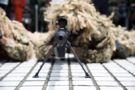 soldier dressed in uniform aims his rifle while on dutyの写真素材
