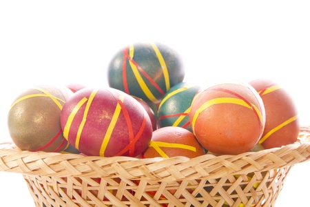 Multi-colored Easter eggs in a wicker tray  dish の写真素材