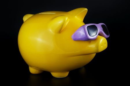 funny piggy bank on a black background with smooth shadowの写真素材