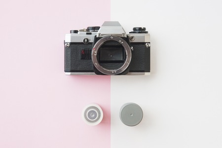 Top View of Analaog SLR Camera with 35 mm Film Canisters on Pinkの写真素材
