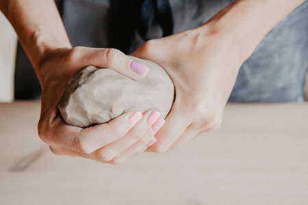 Pottery, clay, ceramics art concept - closeup on hands of young master with the large pieces of...