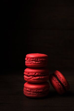Beautiful colorful desserts. French macaroons on a dark wood backgroundの写真素材
