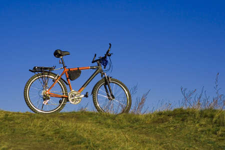 sports bicycle on an autumn meadow against the blue skyの写真素材