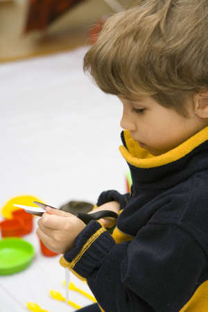 The boy scissors a slice of a white fabricの写真素材