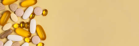 A lot of pills on a yellow background.