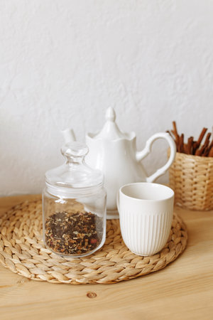 White ceramic teapot and cup on a wooden table. Front view.の写真素材