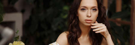 Banner young brunette woman with white flowerの写真素材