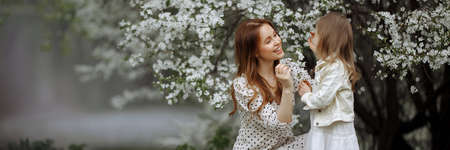 Banner mom and little daughter in the apple orchardの写真素材