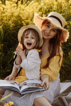 Mom and daughter reading a bookの写真素材