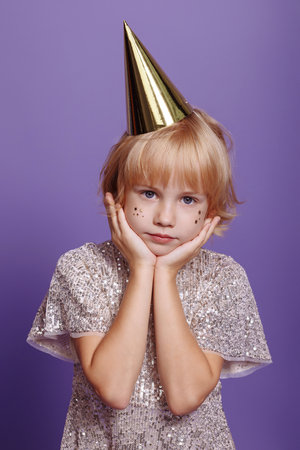 Child in a festive cap on a purple background.の写真素材