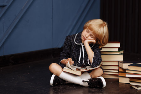 Beautiful girl schoolgirl sleeps at the lessonの写真素材