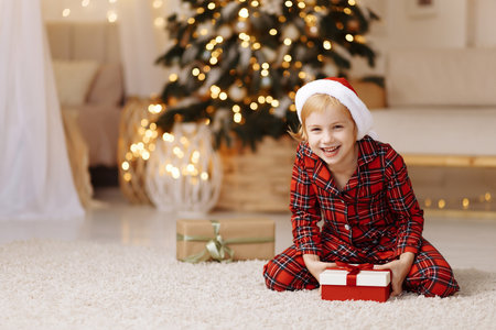 Girl sitting on the floor with a gift in a boxの写真素材