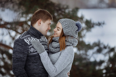The couple hugs and smiles while standing in the snow.の写真素材