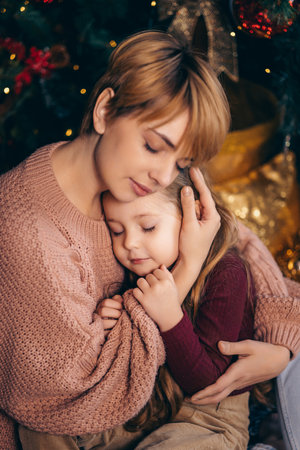 Mom and daughter in a decorated Christmas living room at homeの写真素材