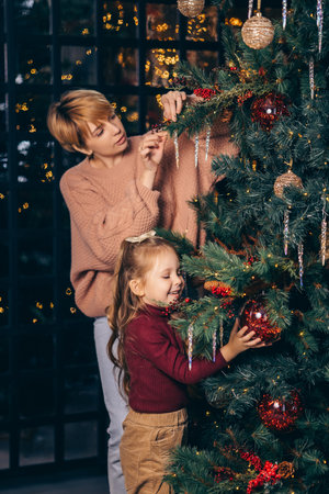 Mom and daughter decorate the Christmas treeの写真素材