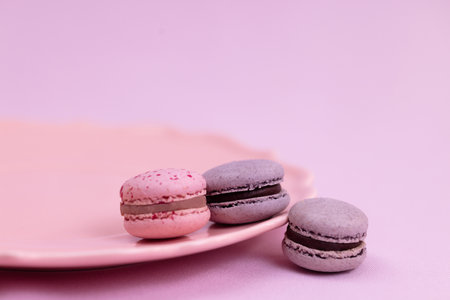 Purple and pink macaron cookies lie on a plateの写真素材