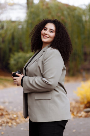A business woman holds a glass of coffee in her hands
