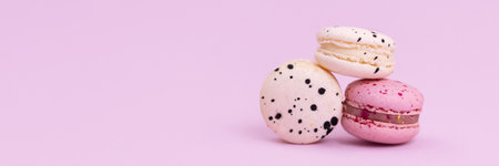 Banner sweet colorful macarons isolated on pink background.