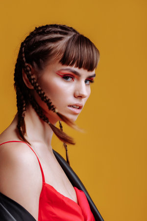 Beautiful female model in a red dress yellow backgroundの写真素材