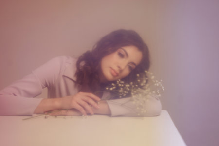 A brunette girl holds a bouquet of gypsophila flowers in her hands.の写真素材